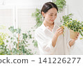 拿著葉子植物的婦女 141226277