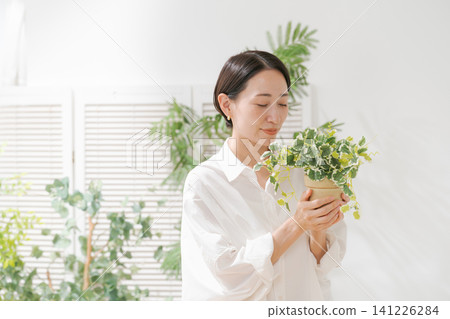 拿著葉子植物的婦女 141226284