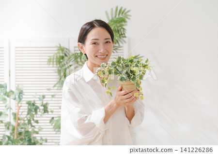 A woman holding a foliage plant A woman holding a foliage plant 141226286