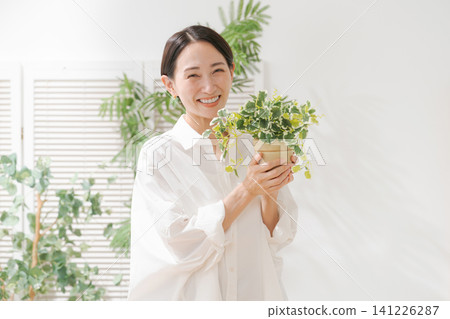 拿著葉子植物的婦女 141226287