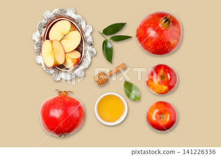 Apples and pomegranates displayed with honey and leaves Apples and pomegranates displayed with honey and leaves 141226336