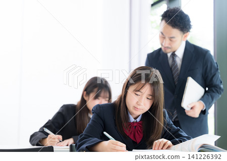 日本國中和高中女生在補習班和學校教室接受老師的一對一輔導。 141226392