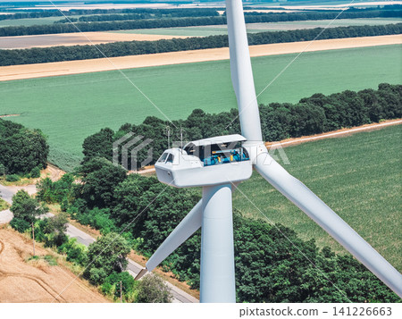 Technician conducting wind turbine maintenance at high altitude Technician conducting wind turbine maintenance at high altitude 141226663