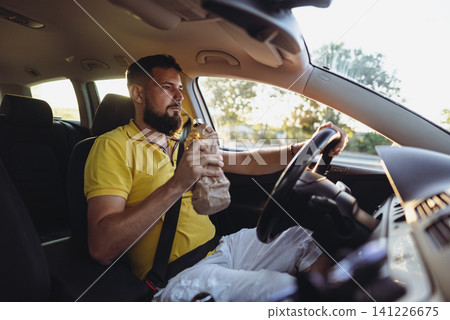 Danger on the Road. Man Drinking While Driving 141226675