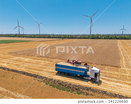 Modern farming equipment collecting wheat crop with wind power generators Modern farming equipment collecting wheat crop with wind power generators 141226680