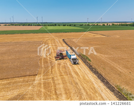 Sustainable farming and renewable energy concept with harvester and turbines Sustainable farming and renewable energy concept with harvester and turbines 141226681