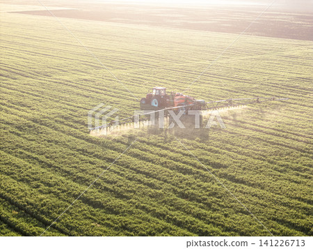 Golden Hour Aerial of Agricultural Spraying Tractor on Field Golden Hour Aerial of Agricultural Spraying Tractor on Field 141226713