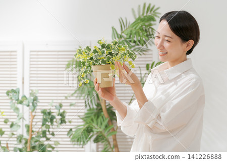 A woman holding a foliage plant A woman holding a foliage plant 141226888