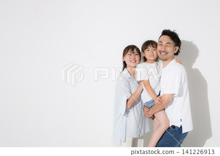 一家人在白色背景前笑容燦爛——幸福的家庭生活和健康的生活方式，穿著短袖，拍攝夏季度假照，直視鏡頭。 141226913