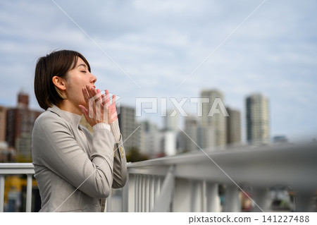 A woman with both hands together 141227488