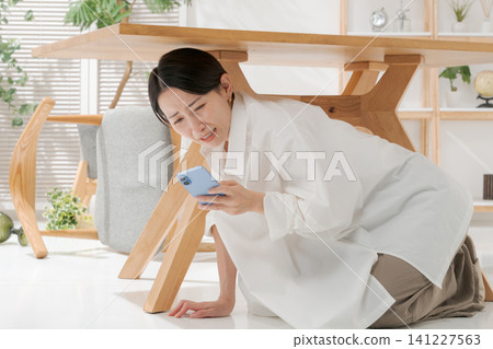 Woman hides under the desk 141227563