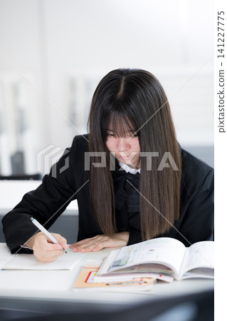 Japanese high school girls diligently studying in the classroom; students studying independently for entrance exams and regular tests. Japanese high school girls diligently studying in the classroom; students studying independently for entrance exams and regular tests. 141227775