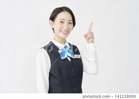 Female staff member pointing to the right; receptionist/bank employee; white background. Female staff member pointing to the right; receptionist/bank employee; white background. 141228089