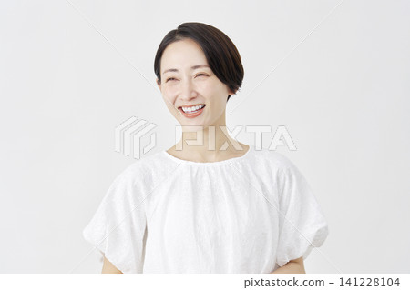 Portrait of a middle-aged woman smiling, against a white background. Portrait of a middle-aged woman smiling, against a white background. 141228104