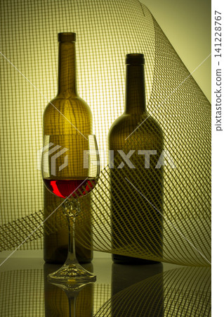 Still life with glass bottles and a glass of red wine Still life with glass bottles and a glass of red wine 141228767