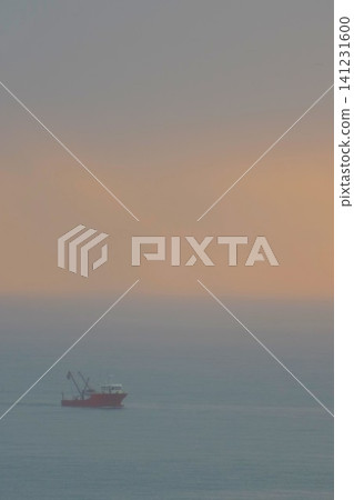 Red fishing boat sailing in thick fog at sunset with copy space Red fishing boat sailing in thick fog at sunset with copy space 141231600