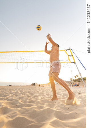 Man playing beach volleyball at sunset Man playing beach volleyball at sunset 141232487