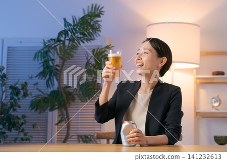 一位穿著西裝的女士正在喝啤酒 一位穿著西裝的女士正在喝啤酒 141232613