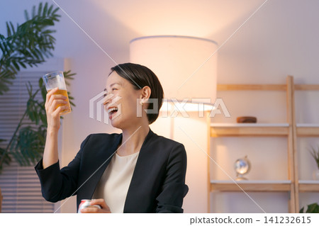 A woman in a suit drinking beer A woman in a suit drinking beer 141232615