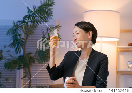 一位穿著西裝的女士正在喝啤酒 一位穿著西裝的女士正在喝啤酒 141232616
