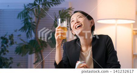 一位穿著西裝的女士正在喝啤酒 一位穿著西裝的女士正在喝啤酒 141232617