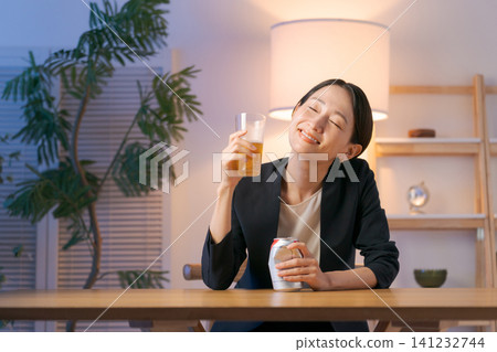 一位穿著西裝的女士正在喝啤酒 一位穿著西裝的女士正在喝啤酒 141232744