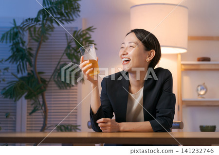 A woman in a suit drinking beer A woman in a suit drinking beer 141232746