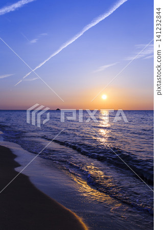 The sunset over the coast, as the sky transitions from blue to a sunset. The sunset over the coast, as the sky transitions from blue to a sunset. 141232844