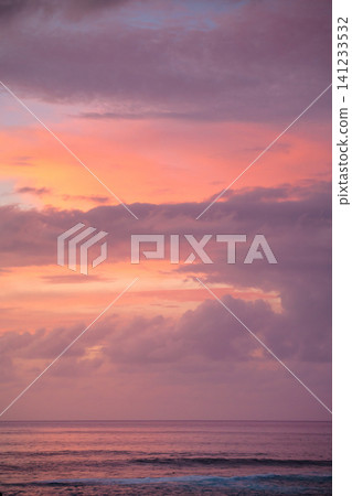 Serene pink sunset sky reflects on ocean at easter island chile Serene pink sunset sky reflects on ocean at easter island chile 141233532