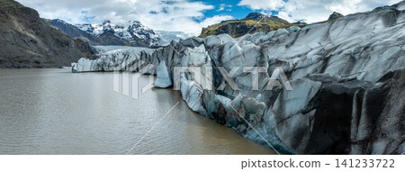 Close view of the impressive Glacier Lagoon in southeast Iceland, where towering blue glacier ice meets calm water ben rugged mountains 141233722