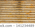 The texture of a shutter with peeling paint and rust due to age-related deterioration, an industrial yet nostalgic background material. 141234489