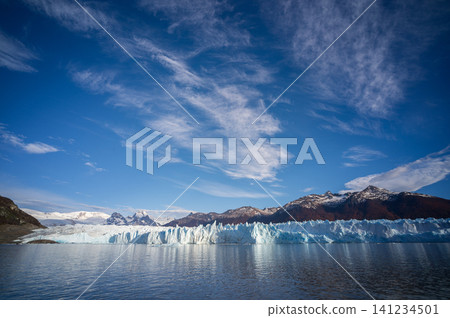 Perito moreno glacier patagonia los glaciares national park, blue ice wall above calm lake under wide sky 141234501