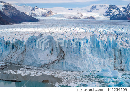 Glaciers perito moreno glacier ice field mountain landscape cold blue ice wall icy water dramatic scenic view of glacier ice with mountain range 141234509