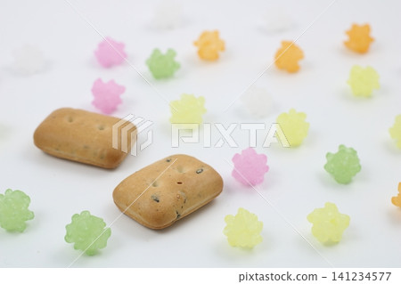 硬餅乾(一種醃製食品)和色彩鮮豔的金平糖(糖果)作為背景。 硬餅乾(一種醃製食品)和色彩鮮豔的金平糖(糖果)作為背景。 141234577