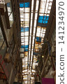 The arcade ceiling shows signs of age and deterioration, the corrugated iron sheets are patched together, and the shopping street retains a sense of everyday life. 141234970