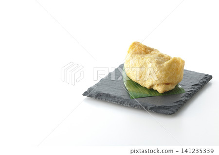 Inari sushi on a slate plate photographed against a white background. Inari sushi on a slate plate photographed against a white background. 141235339