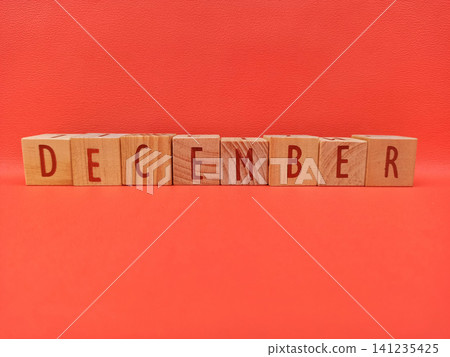 Wooden Blocks Spell Out December on Red Background - Winter Month Concept Wooden Blocks Spell Out December on Red Background - Winter Month Concept 141235425