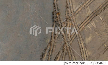 Aerial view wheel tire track on mud, Tire mark imprints on mud vehicles tires footprints transport ground trace or marks textures, wheel treads, Mud terrain. Aerial view wheel tire track on mud, Tire mark imprints on mud vehicles tires footprints transport ground trace or marks textures, wheel treads, Mud terrain. 141235828