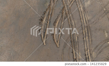 Aerial view wheel tire track on mud, Tire mark imprints on mud vehicles tires footprints transport ground trace or marks textures, wheel treads, Mud terrain. Aerial view wheel tire track on mud, Tire mark imprints on mud vehicles tires footprints transport ground trace or marks textures, wheel treads, Mud terrain. 141235829