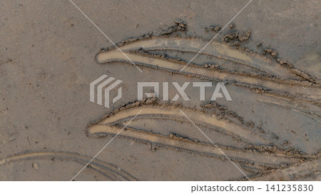 Aerial view wheel tire track on mud, Tire mark imprints on mud vehicles tires footprints transport ground trace or marks textures, wheel treads, Mud terrain. Aerial view wheel tire track on mud, Tire mark imprints on mud vehicles tires footprints transport ground trace or marks textures, wheel treads, Mud terrain. 141235830