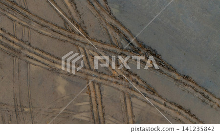Aerial view wheel tire track on mud, Tire mark imprints on mud vehicles tires footprints transport ground trace or marks textures, wheel treads, Mud terrain. Aerial view wheel tire track on mud, Tire mark imprints on mud vehicles tires footprints transport ground trace or marks textures, wheel treads, Mud terrain. 141235842