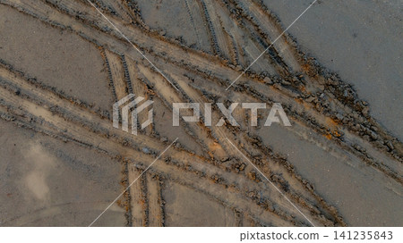 Aerial view wheel tire track on mud, Tire mark imprints on mud vehicles tires footprints transport ground trace or marks textures, wheel treads, Mud terrain. Aerial view wheel tire track on mud, Tire mark imprints on mud vehicles tires footprints transport ground trace or marks textures, wheel treads, Mud terrain. 141235843