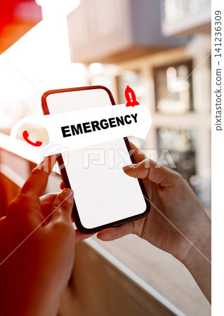 Emergency service call on a smartphone with urgent alert notification in a modern setting during daytime Emergency service call on a smartphone with urgent alert notification in a modern setting during daytime 141236309