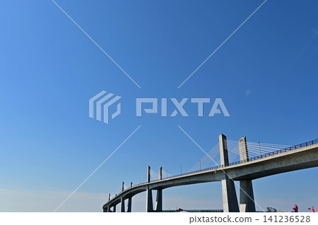 A wide, horizontal view looking up at the main tower of the Onahama Marine Bridge against a clear, vast blue sky, with plenty of space for copying. A wide, horizontal view looking up at the main tower of the Onahama Marine Bridge against a clear, vast blue sky, with plenty of space for copying. 141236528