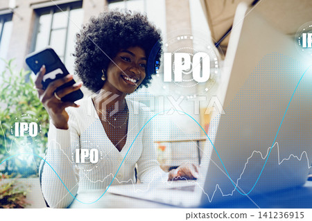Investing in an IPO as a young woman uses a laptop and smartphone outdoors 141236915