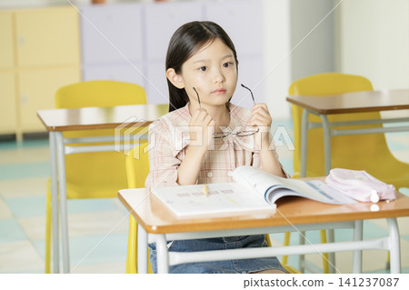 Child student focusing on a textbook during class Child student focusing on a textbook during class 141237087
