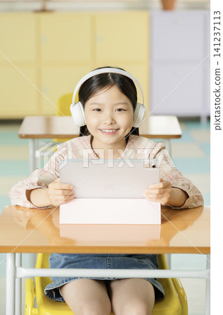 Young student learning online with a laptop in class Young student learning online with a laptop in class 141237113