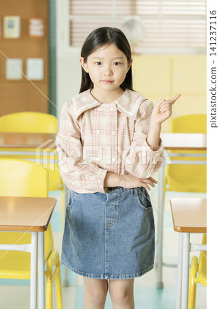 Schoolgirl wearing a backpack in an elementary school classroom Schoolgirl wearing a backpack in an elementary school classroom 141237116