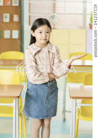 Young student presenting in a bright classroom Young student presenting in a bright classroom 141237119