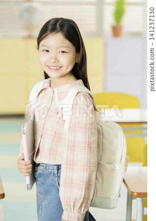 Young student presenting in a bright classroom Young student presenting in a bright classroom 141237130